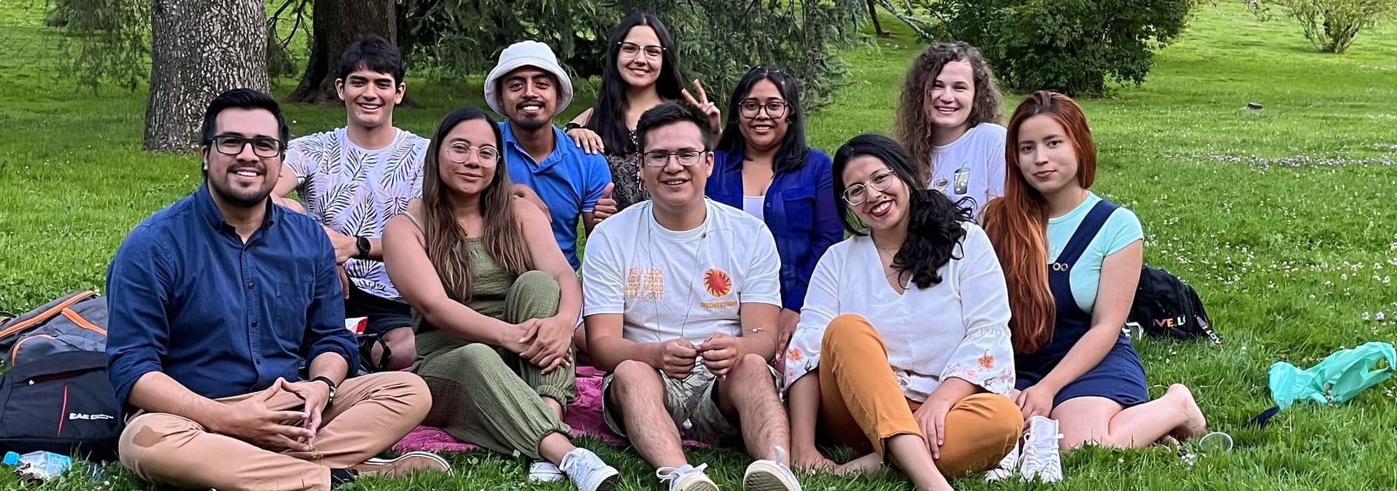 Anthony Araujo, sentado a la izquierda, junto a un grupo de jóvenes en un parque.