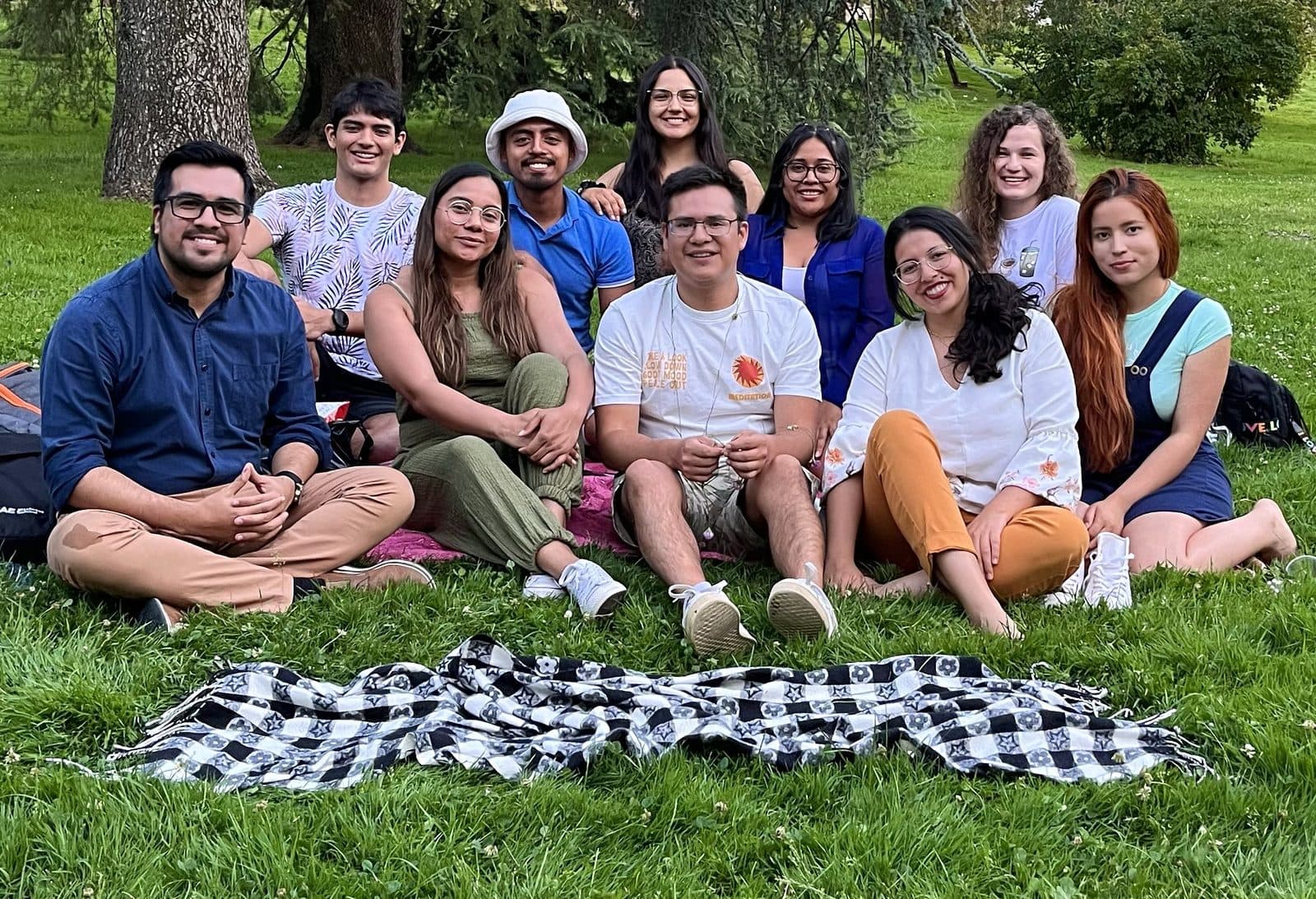 Anthony Araujo, sentado a la izquierda, junto a un grupo de jóvenes en un parque.