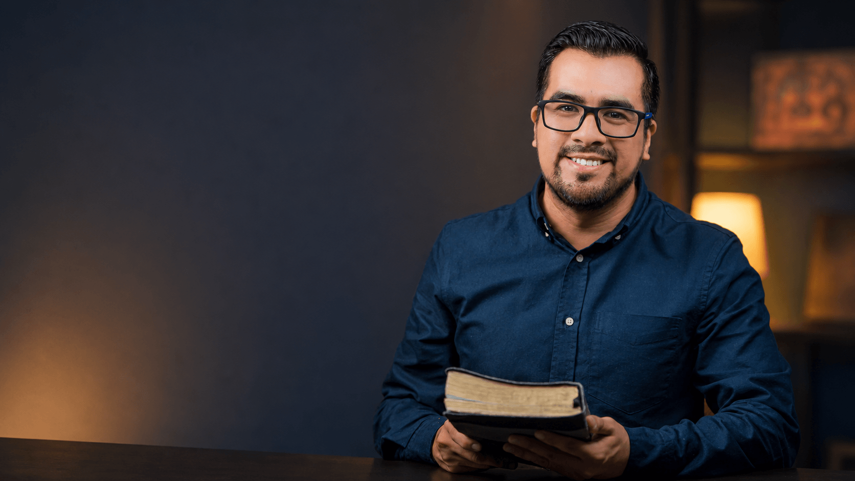 Anthony Araujo sonriendo mientras sostiene una Biblia.